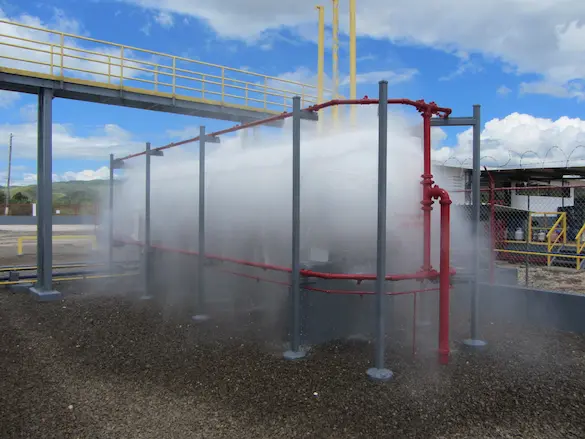 Activated deluge flood fire suppression system discharging water from open nozzles after fire detection system triggers valve release