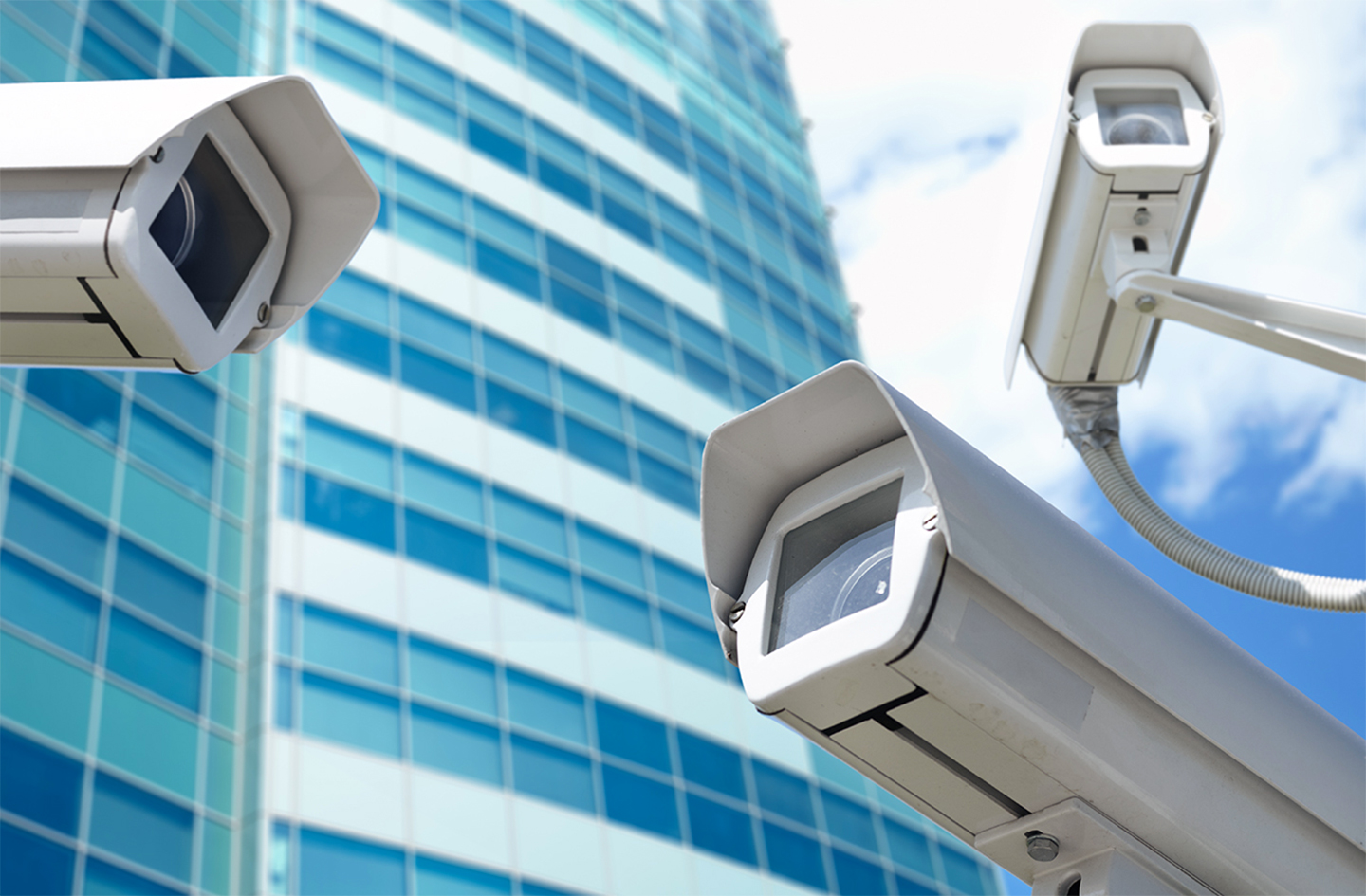 Multiple bullet surveillance cameras mounted and facing different directions for wide-area security coverage