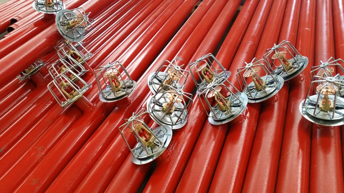 Fire sprinkler pipes with installed sprinklers providing fire protection and automatic suppression in building infrastructure.