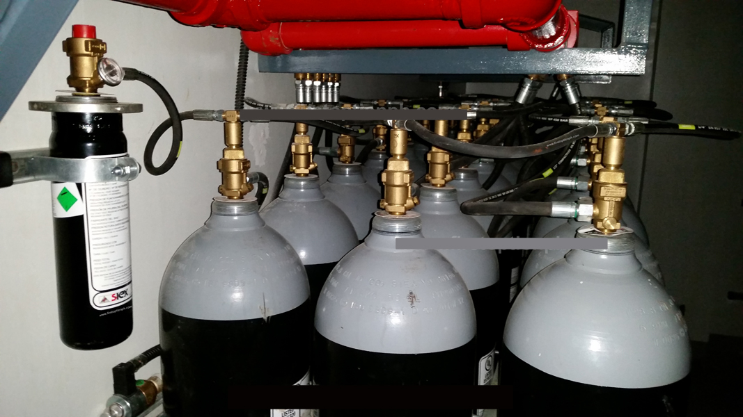 Multiple black CO2 extinguishing gas cylinders aligned in a fire suppression system